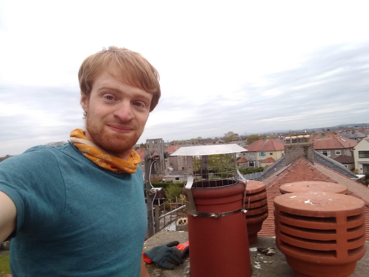 James Denley on a rooftop beside a newly fitted chimney cowl