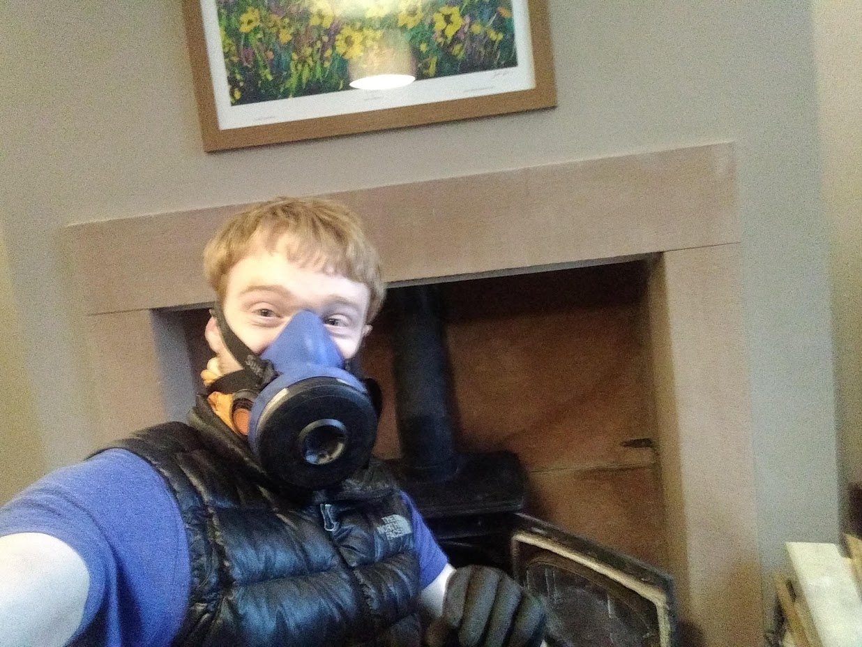 James Denley in respirator and PPE working at a stove hearth