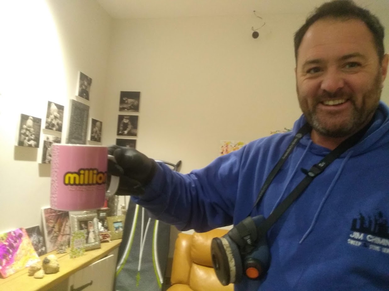 Jim of Jim Chimney holding a mug of tea in his workwear